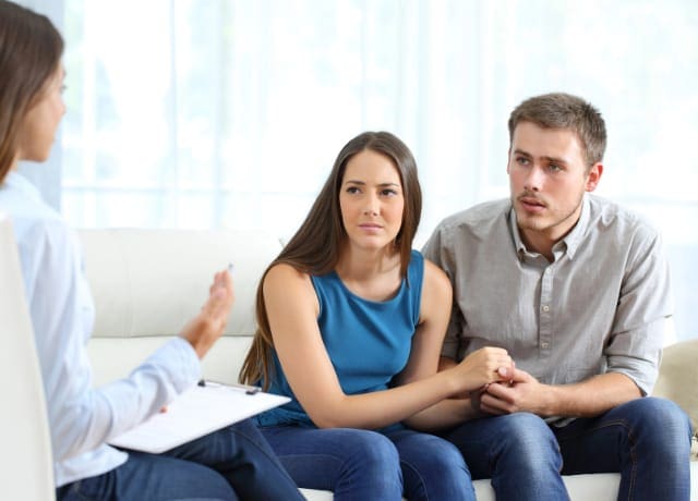 Worried couple listening to marriage counselor