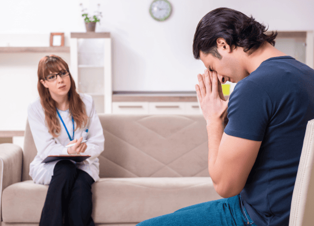 Young male patient discussing with female psychologist